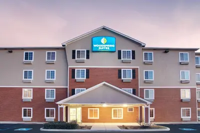 a hotel with a sign on top of it at WoodSpring Suites Fort Wayne in Fort Wayne