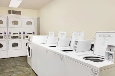 a laundry room with white washing machines and cabinets at WoodSpring Suites Fort Wayne in Fort Wayne