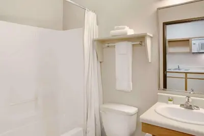 a bathroom with a toilet and a sink and a shower at WoodSpring Suites Fort Wayne in Fort Wayne