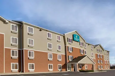 a large building with a sign on the side of it at WoodSpring Suites Fort Wayne in Fort Wayne