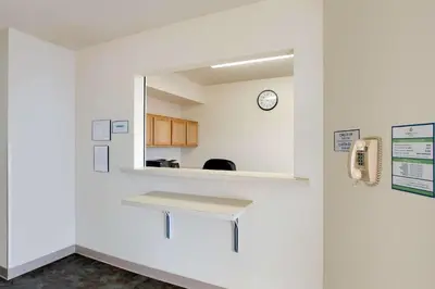a waiting room with a bench and a clock on a wall at WoodSpring Suites Fort Wayne in Fort Wayne