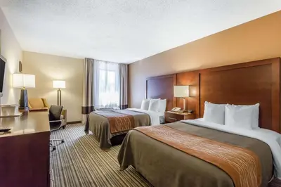 a hotel room with two beds and a desk at Comfort Inn - Hall of Fame in Canton