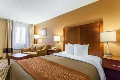 a hotel room with a large bed and a chair at Comfort Inn - Hall of Fame in Canton