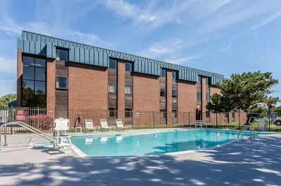 a building with a swimming pool in front of a building at Comfort Inn - Hall of Fame in Canton
