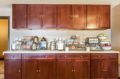a kitchen with wooden cabinets and a counter top at Comfort Inn - Hall of Fame in Canton