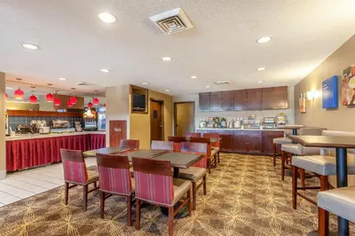 a restaurant with a table and chairs and a kitchen at Comfort Inn - Hall of Fame in Canton