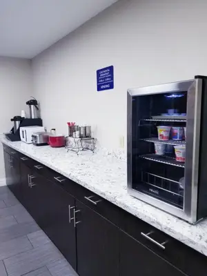 a kitchen with a counter with an open microwave oven at Microtel Inn & Suites by Wyndham Riverside in Dayton