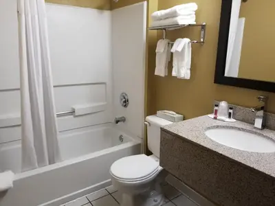 a bathroom with a toilet and a sink and a tub at Microtel Inn & Suites by Wyndham Riverside in Dayton