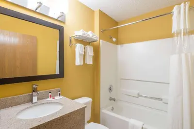 a bathroom with a sink and a toilet and a tub at Microtel Inn & Suites by Wyndham Riverside in Dayton