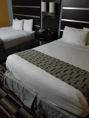 two beds sitting next to each other in a hotel room at Microtel Inn & Suites by Wyndham Riverside in Dayton