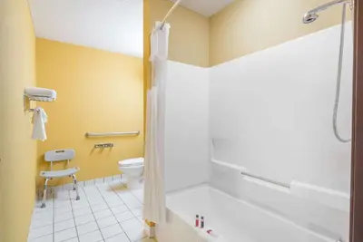 a bathroom with a tub and a toilet and a shower at Microtel Inn & Suites by Wyndham Riverside in Dayton
