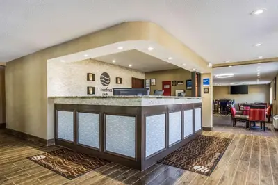 a hotel lobby with a reception counter and a restaurant at Comfort Inn Norwalk - Sandusky in Norwalk