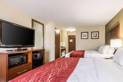 a hotel room with two beds and a flat screen tv at Comfort Inn Norwalk - Sandusky in Norwalk