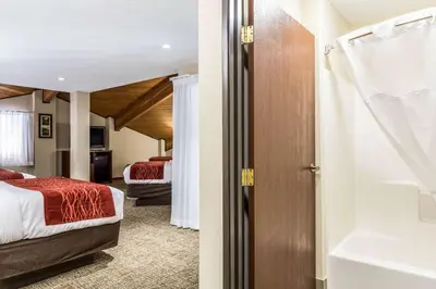 a hotel room with two beds and a bathroom at Comfort Inn Norwalk - Sandusky in Norwalk
