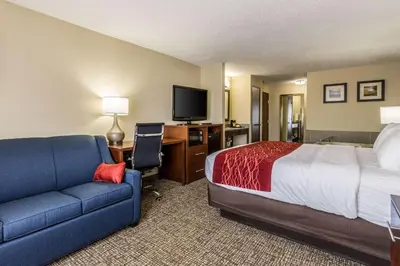 a hotel room with a bed and a couch and a desk at Comfort Inn Norwalk - Sandusky in Norwalk