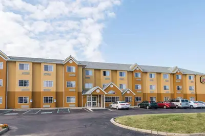a large yellow building with cars parked in a parking lot at Super 8 by Wyndham Columbus West in Columbus