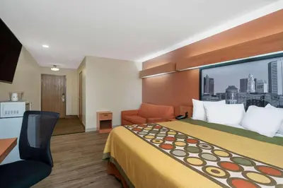 a hotel room with a bed and a large window at Super 8 by Wyndham Columbus West in Columbus