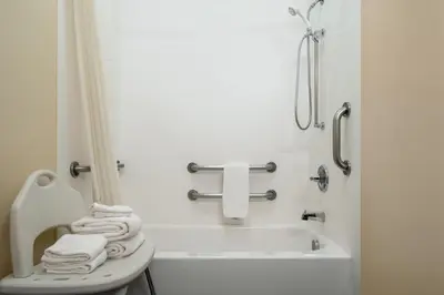 a bathroom with a tub and a toilet and towels at Super 8 by Wyndham Columbus West in Columbus