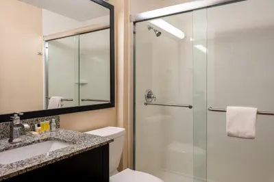a bathroom with a shower and a toilet and a sink at Super 8 by Wyndham Columbus West in Columbus