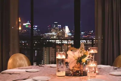a table with candles and flowers and a view of the city at Radisson Hotel Cincinnati Riverfront in Covington