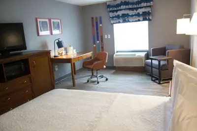 a hotel room with a bedroom with a desk and a bed at Hampton Inn Marion in Marion