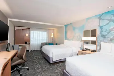 a hotel room with two beds and a desk at Courtyard by Marriott Cleveland Elyria in Elyria