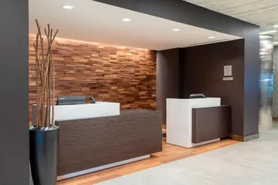 a lobby with two reception desks and a brick wall at Courtyard by Marriott Cleveland Elyria in Elyria