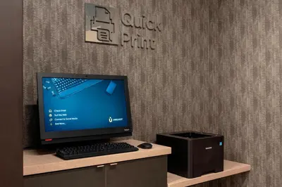 a computer monitor and a printer sitting on a desk at Courtyard by Marriott Cleveland Elyria in Elyria