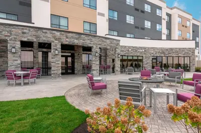 a patio with purple chairs and tables in front of a building at Courtyard by Marriott Cleveland Elyria in Elyria