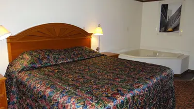 a hotel room with a bed and a bath tub at Stay Inn in Port Clinton