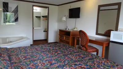 a hotel room with a bed and a desk and a sink at Stay Inn in Port Clinton