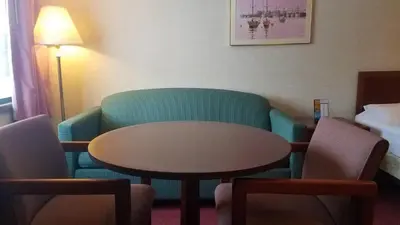 a hotel room with a table and a couch and a bed at Stay Inn in Port Clinton