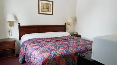 a bedroom with a bed with a colorful comforter at Stay Inn in Port Clinton