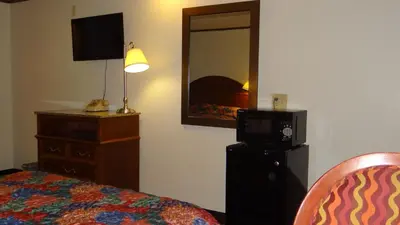 a bedroom with a bed and a dresser and a mirror at Stay Inn in Port Clinton