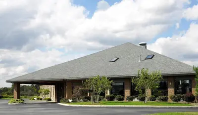 a building with a gray roof on a street at Best Western Norwalk in Norwalk