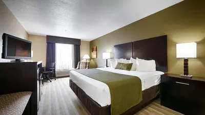 a hotel room with a bed and a flat screen tv at Best Western Norwalk in Norwalk
