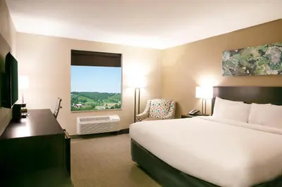 a hotel room with a large bed and a window at Berlin Encore Hotel & Suites in Berlin