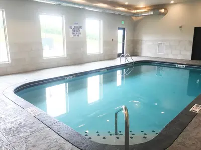 a large swimming pool with blue water in a building at Berlin Encore Hotel & Suites in Berlin