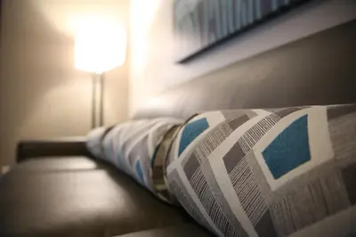 a newspaper laying on a bed next to a lamp at Berlin Encore Hotel & Suites in Berlin