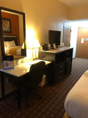 a hotel room with a desk and a mirror at Baymont by Wyndham Cincinnati Sharonville in Sharonville