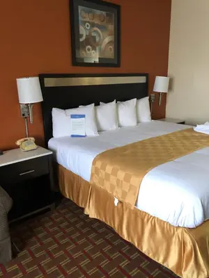 a hotel room with two beds and a desk with lamps at Baymont by Wyndham Cincinnati Sharonville in Sharonville