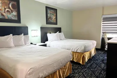 a hotel room with two beds with white sheets at Baymont by Wyndham Cincinnati Sharonville in Sharonville