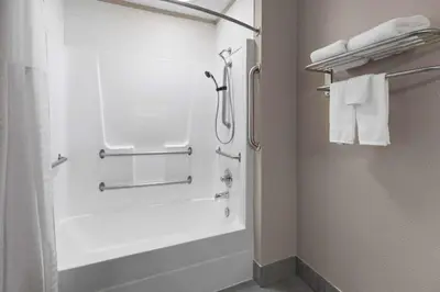 a bathroom with a shower and a bath tub with towels at Super 8 by Wyndham Bridgeport/Clarksburg Area in Bridgeport