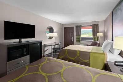 a hotel room with a bed and a flat screen tv at Super 8 by Wyndham Bridgeport/Clarksburg Area in Bridgeport