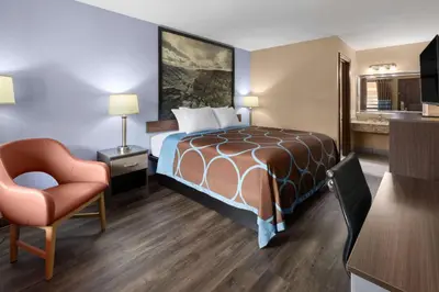 a hotel room with a bed and a chair at Super 8 by Wyndham Bridgeport/Clarksburg Area in Bridgeport