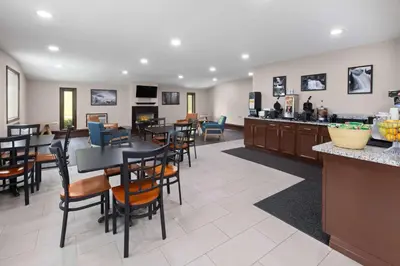 a restaurant with tables and chairs and a bar at Super 8 by Wyndham Bridgeport/Clarksburg Area in Bridgeport