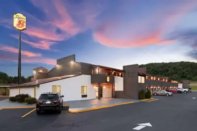 a building with a car parked in a parking lot at Super 8 by Wyndham Bridgeport/Clarksburg Area in Bridgeport