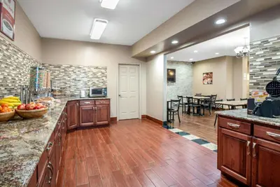 a large kitchen with wooden cabinets and a dining room at Econo Lodge Shelbyville North in Shelbyville