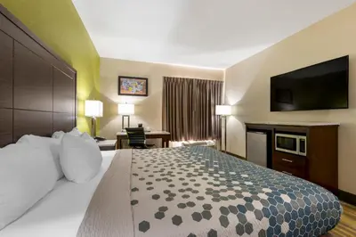 a hotel room with a bed and a flat screen tv at Econo Lodge Shelbyville North in Shelbyville