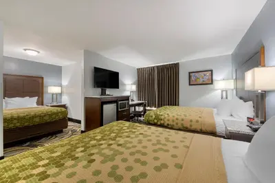 a hotel room with two beds and a flat screen tv at Econo Lodge Shelbyville North in Shelbyville